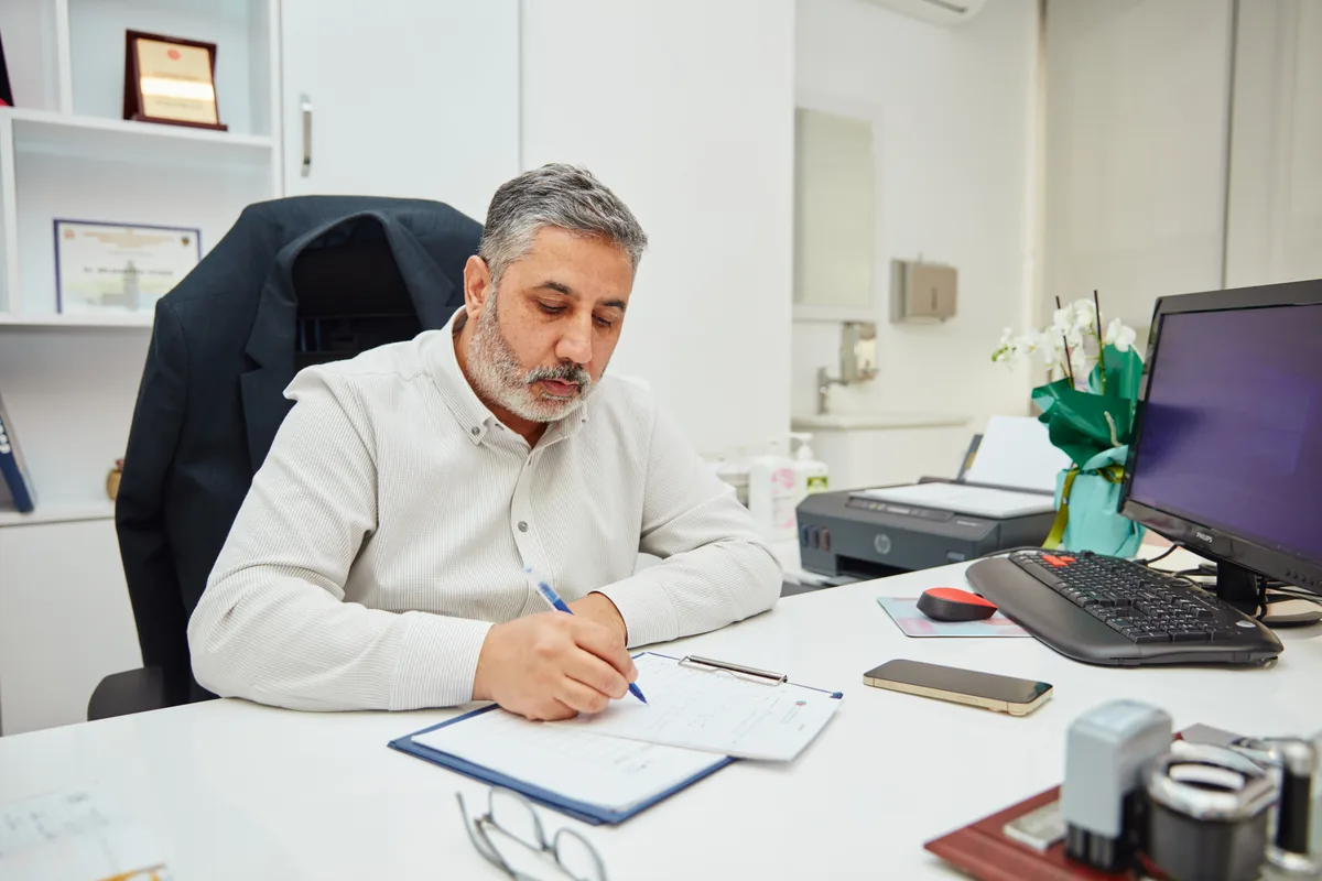 Op. Dr. Selahattin Yitgin muayene sonrası notlarını yazarken
