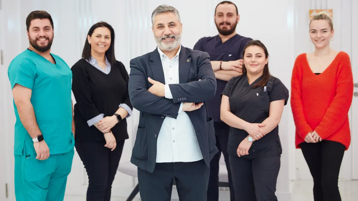Genel Cerrahi ve Proktoloji Uzmanı Op. Dr. Selahattin Yitgin, İstanbul Şişli kliniğinde deneyimli sağlık ekibiyle birlikte gülümserken.